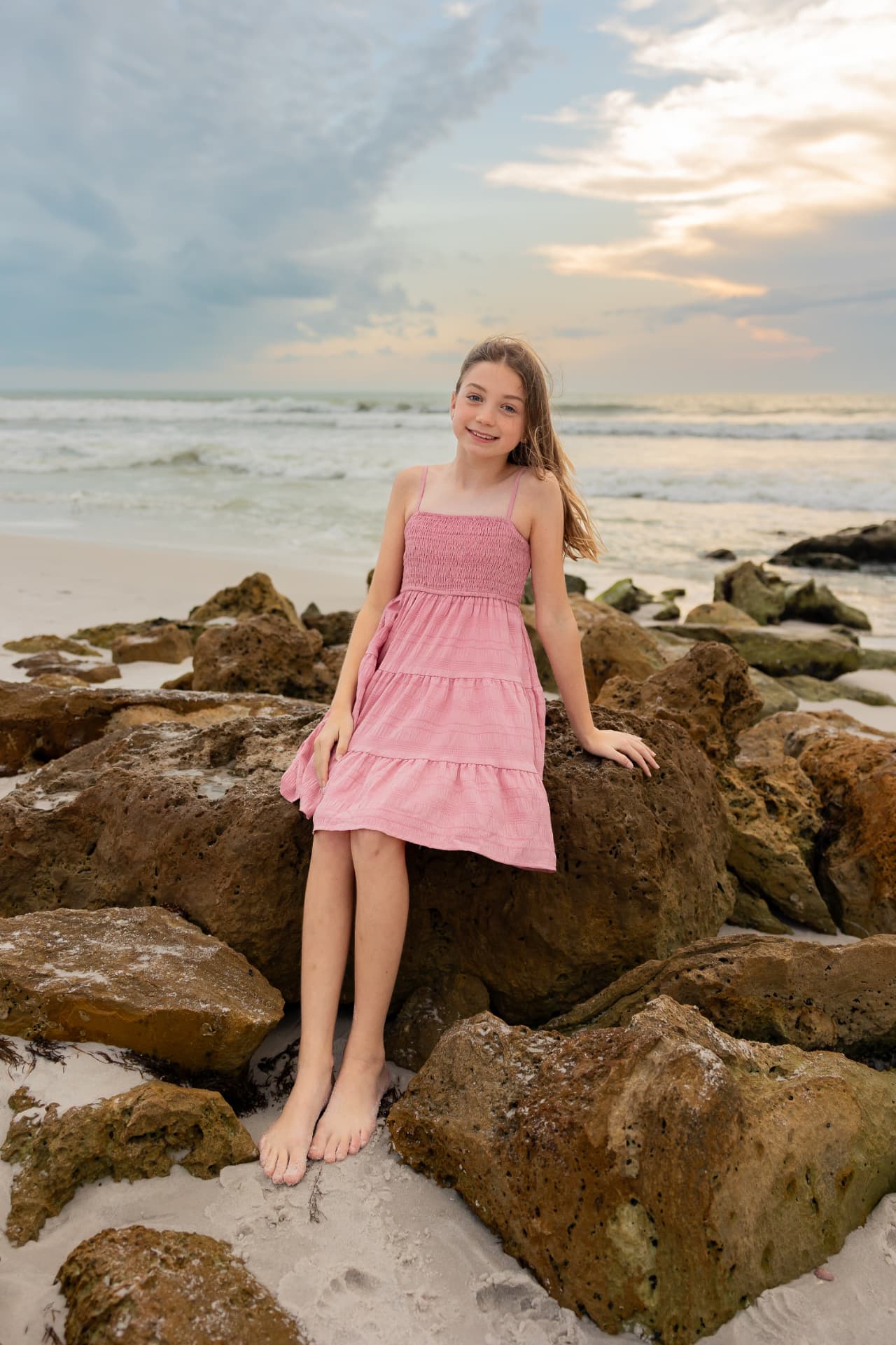 Elle, founder of Tic Tac Float, smiling on the rocks at a Naples beach